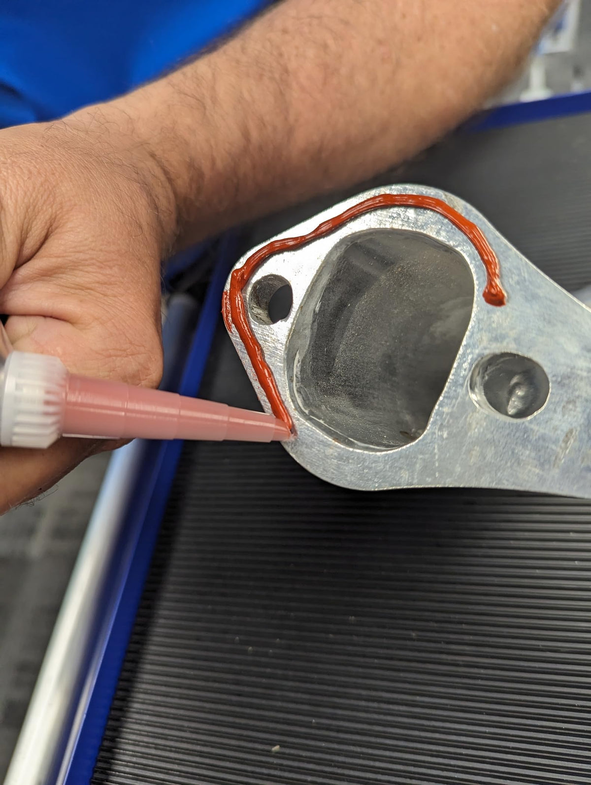 Permatex 81409 close-up of red RTV bead texture demonstrating smooth application and adhesion