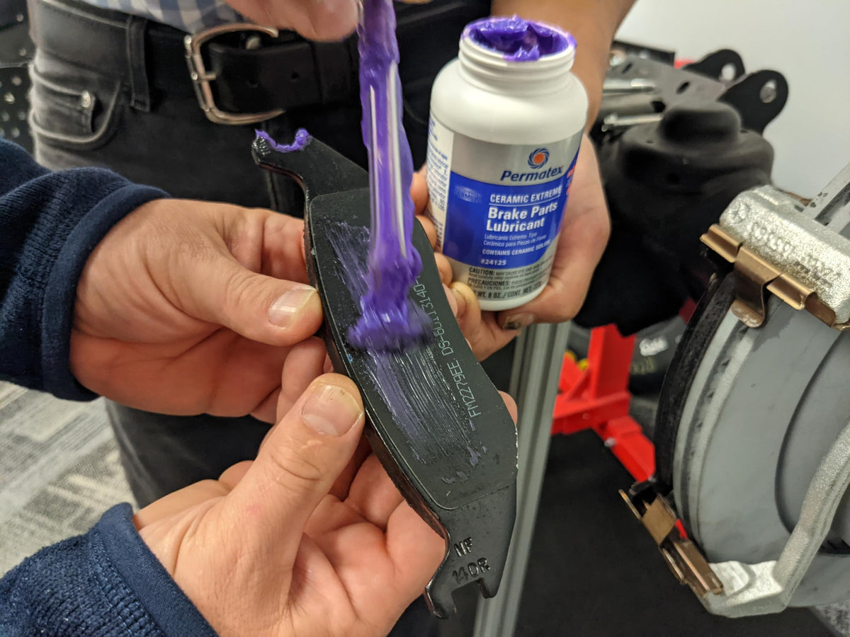 Permatex applied to caliper slide demonstrating noise reduction