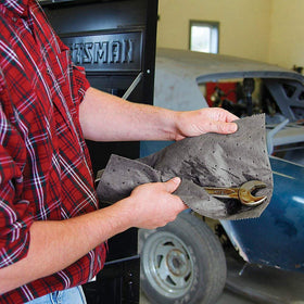 PIG mat soaking oil spill on garage floor demonstrating quick cleanup benefit