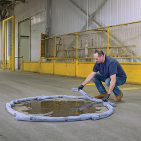 PIG sock absorbing oil spill on concrete demonstrating rapid containment benefit