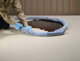 PIG socks deployed diking a spill on a factory floor to prevent spread