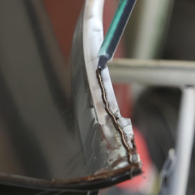 Polymix on workbench with tools and clamp, suggests professional repair workflow