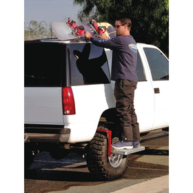 Powerbuilt step in use on a pickup tire reaching roof rack for safer loading