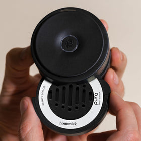 Pura diffuser mounted in car dispersing scent for an invigorating commute by Pura