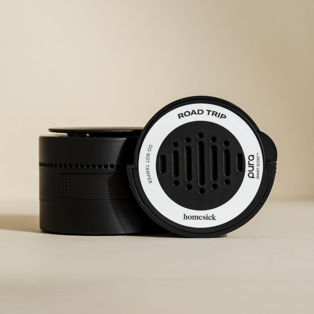 Hand holding Pura Homesick refill to show compact size and easy replacement