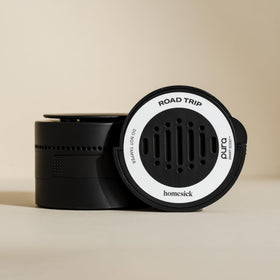 Hand holding Pura Homesick refill to show compact size and easy replacement