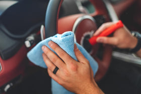 The Rag Company towel cleaning a cupholder and interior trim for lint-free results
