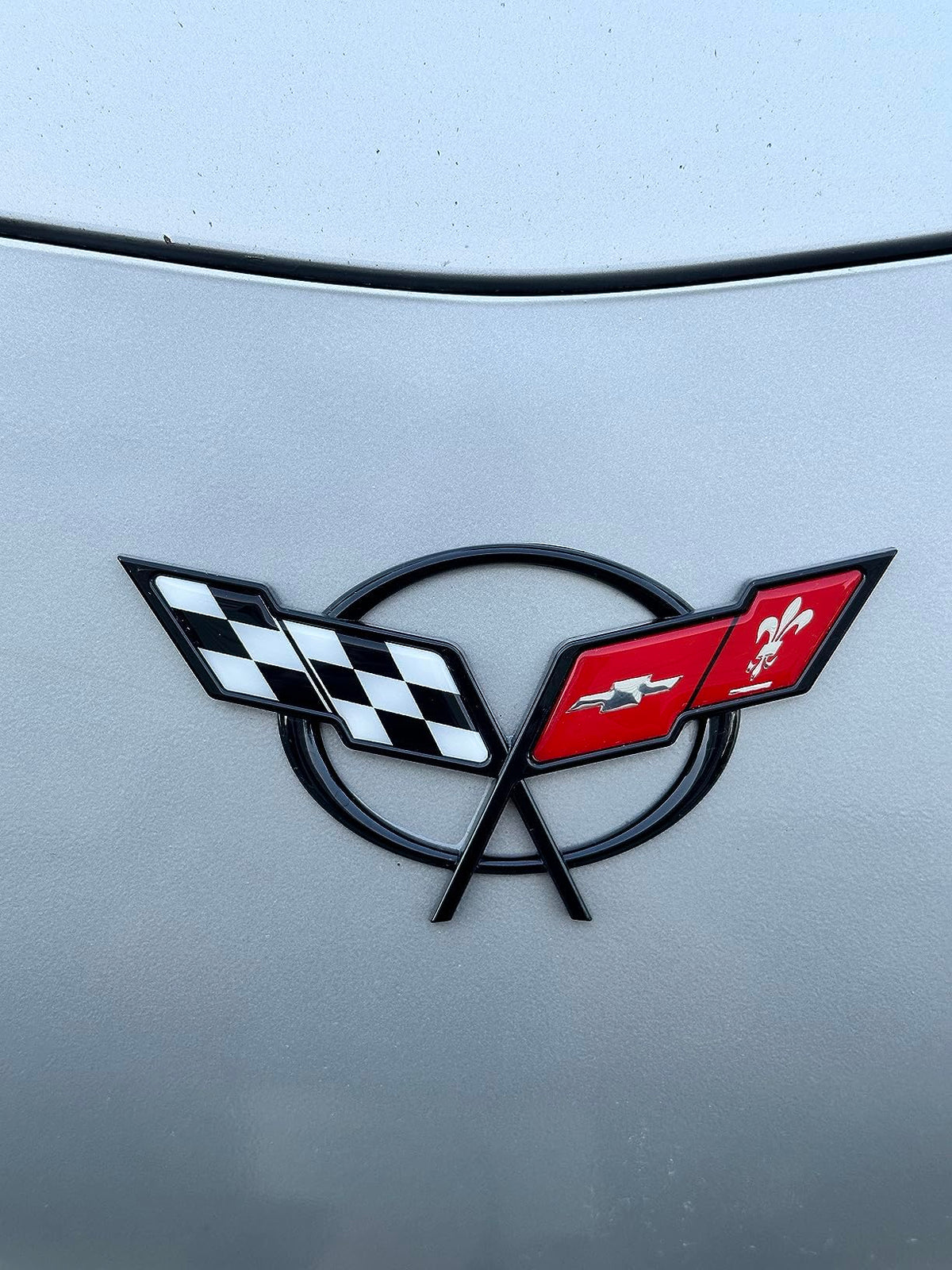 REIXS installed emblem on Corvette front nose illustrating authentic OEM appearance