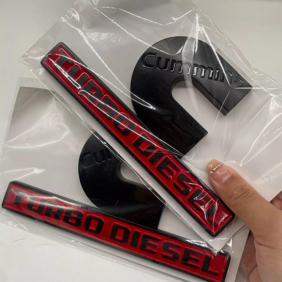 REOPEAI front view of two emblems showing black red finish and instant style