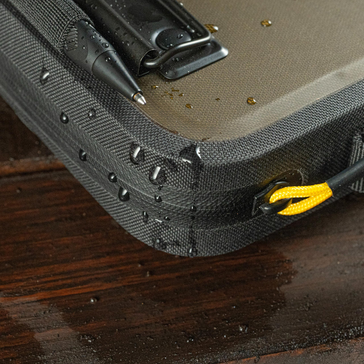 Rite in the Rain powder-coated clip close-up securing paper against wind
