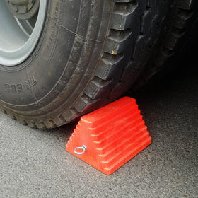 ROBLOK chock placed under travel trailer tire on gravel, prevents rolling