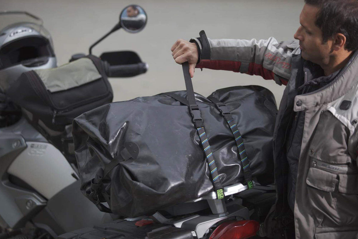 ROK Straps securing luggage on a motorcycle rack, reflective thread visible, safer transport