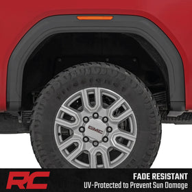 Rough Country-equipped Sierra driving on road showing refined appearance