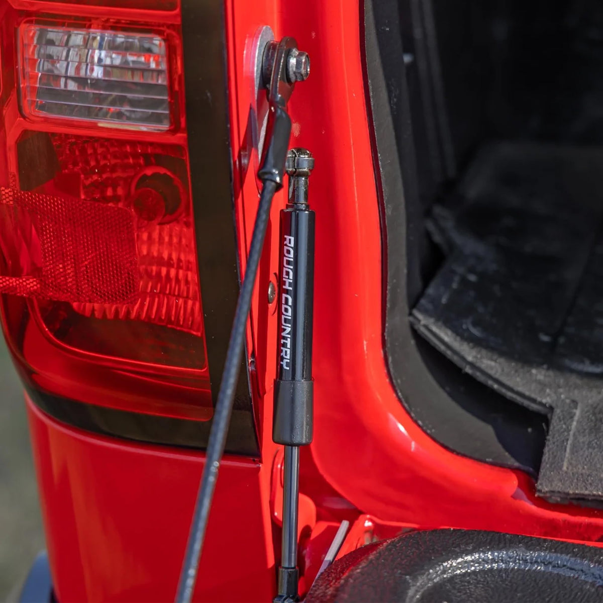 Rough Country tailgate assist beside ruler showing size and simple installation advantage