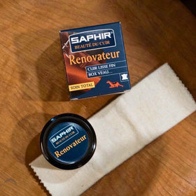 SAPHIR Renovateur jar beside coin for scale, emphasizes travel-friendly compactness benefit
