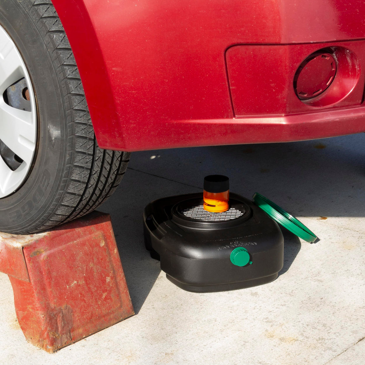 Scepter pan positioned under car catching oil for cleaner maintenance