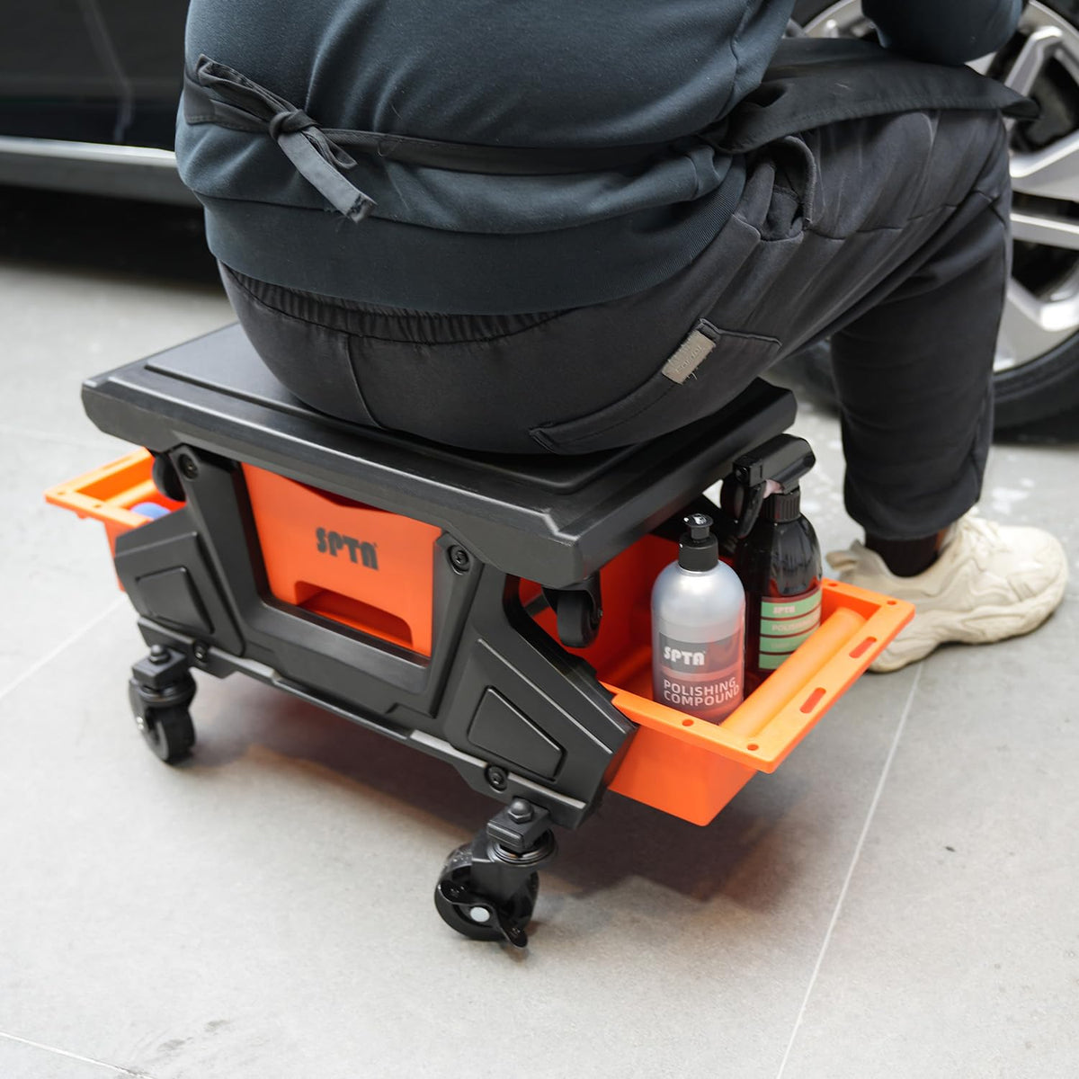 SPTA in garage lifestyle shot with mechanic using seat, speeds up car tasks