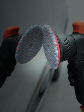 SPTA wool pad staged with polisher and compounds in a detailing kit