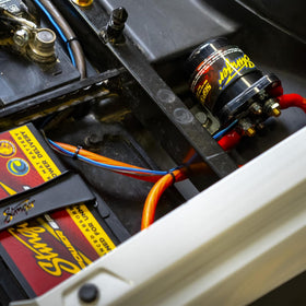 STINGER SGP32 next to a car battery showing compact size and installation scale