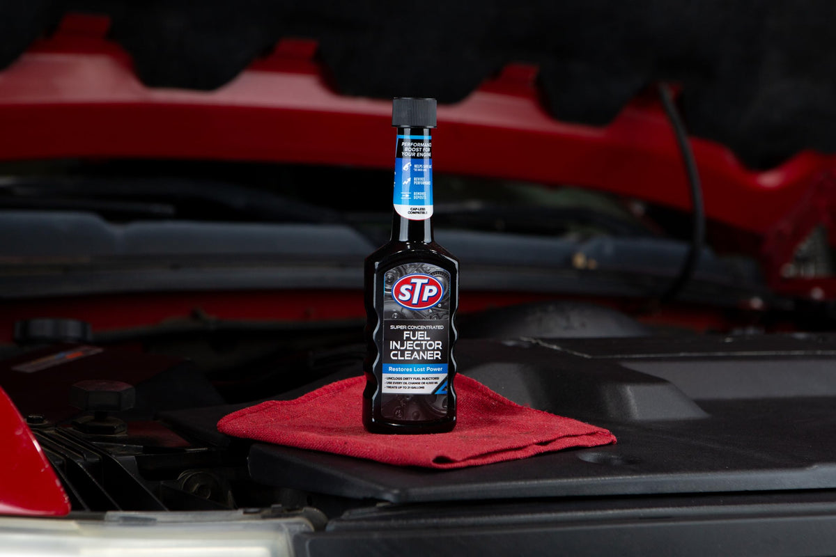STP bottle in a garage scene showing practical use and maintenance-ready benefit