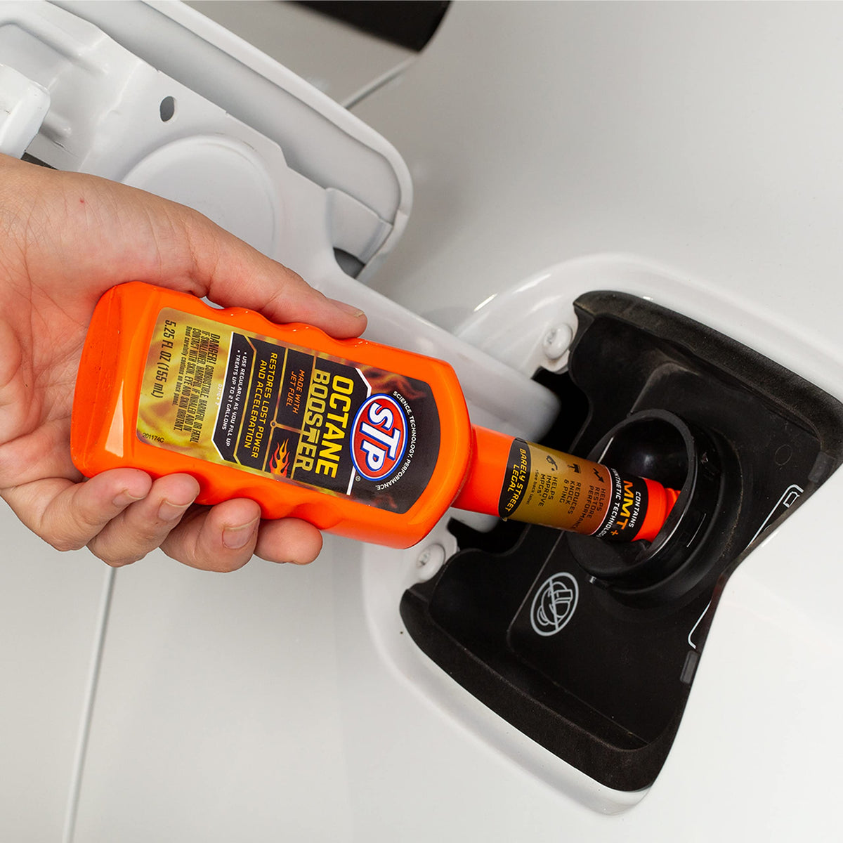 STP Octane Booster pouring into gas tank demonstrating easy pour and quick use benefit