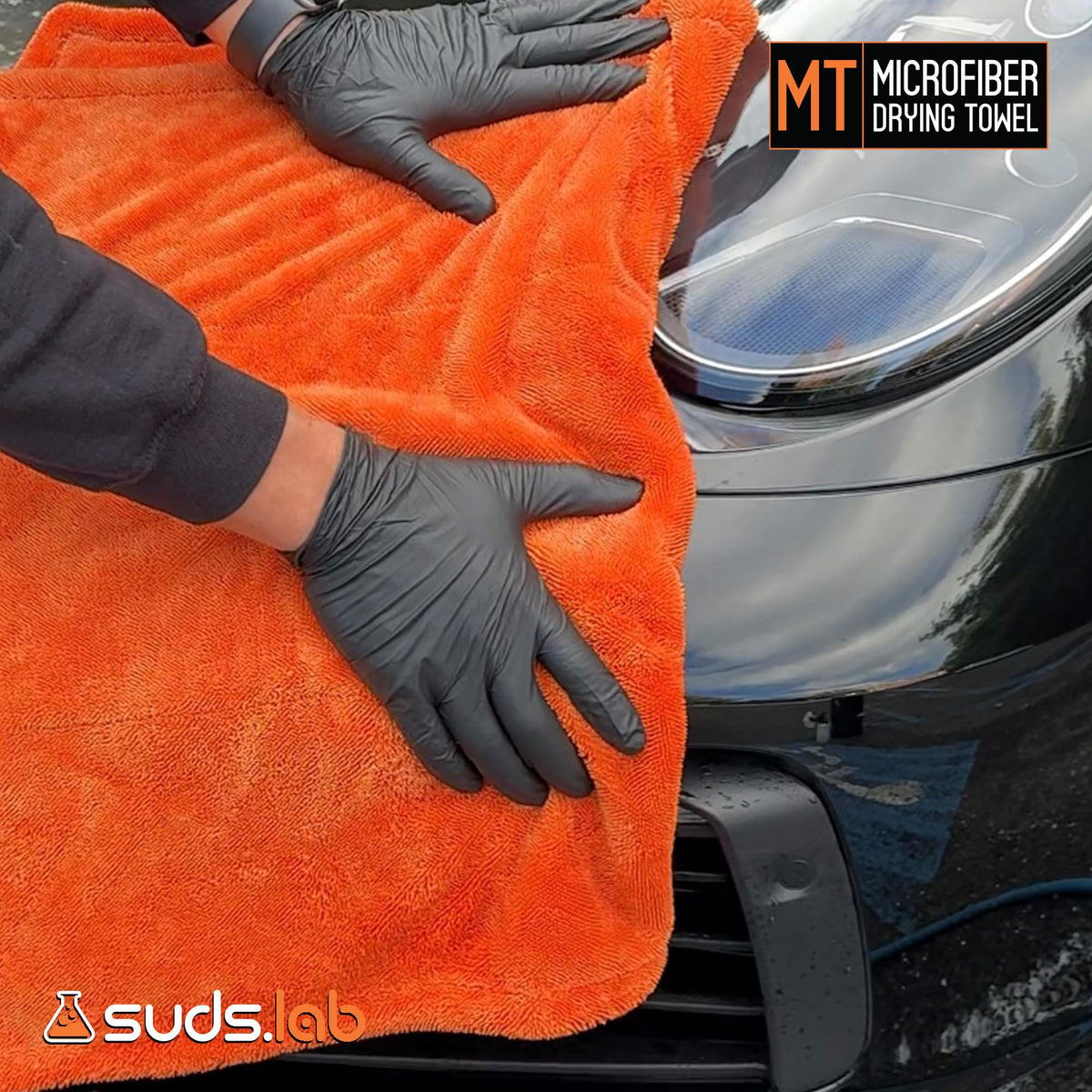 suds.lab towel next to wax bottle illustrating compatibility with detailing products benefit