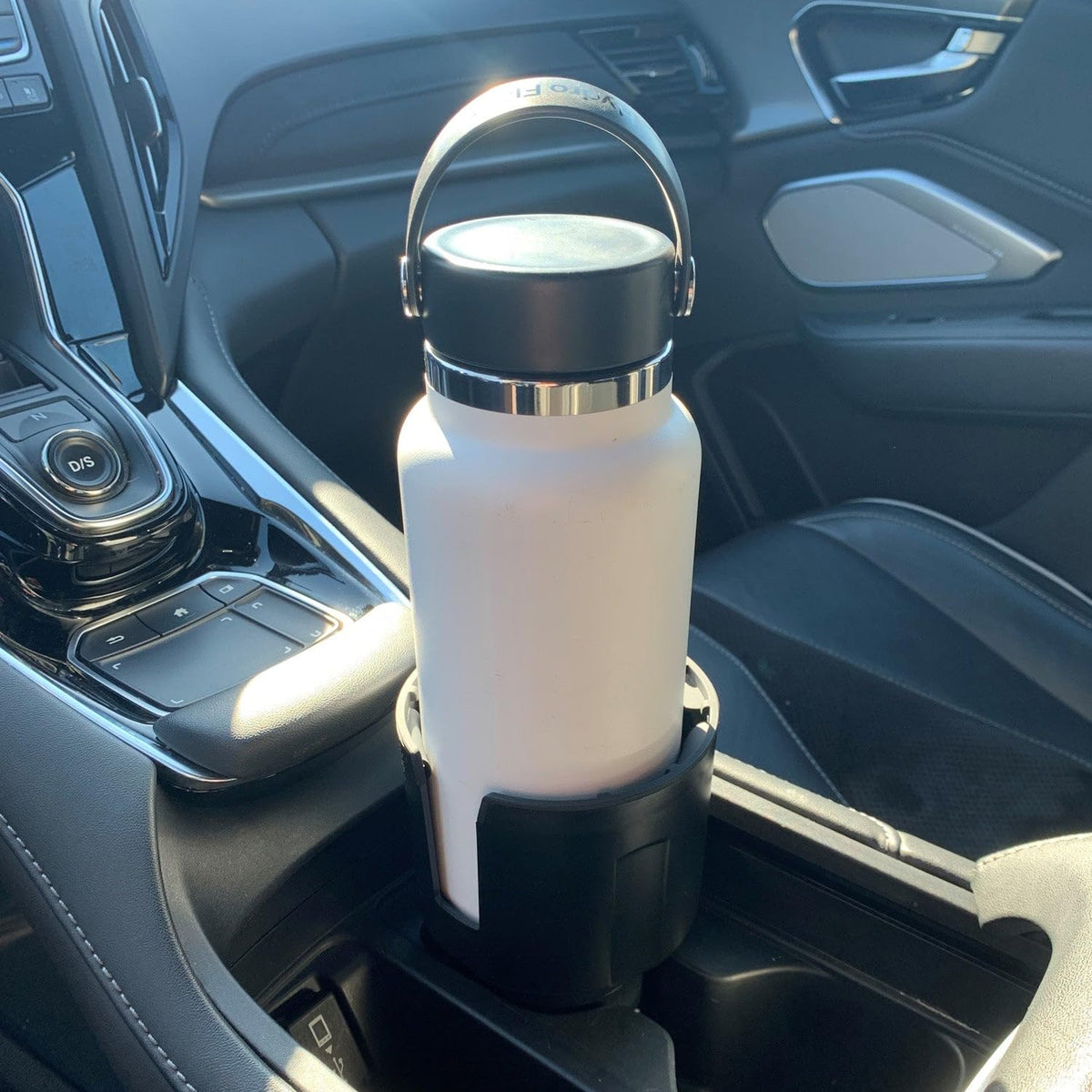 Swigzy installed in car console keeping a large bottle secure while driving