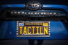 TACTILIAN frame beside standard license plate showing universal fit