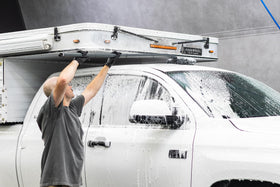 The Rag Company extension in use on an RV window for safer high-access cleaning