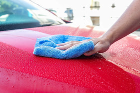 The Rag Company towels staged in a garage setting for professional detailing workflow