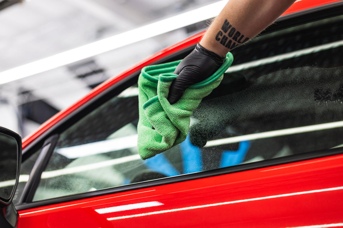 The Rag Company FTW towel cleaning a mirror for streak-free reflection and easy polishing