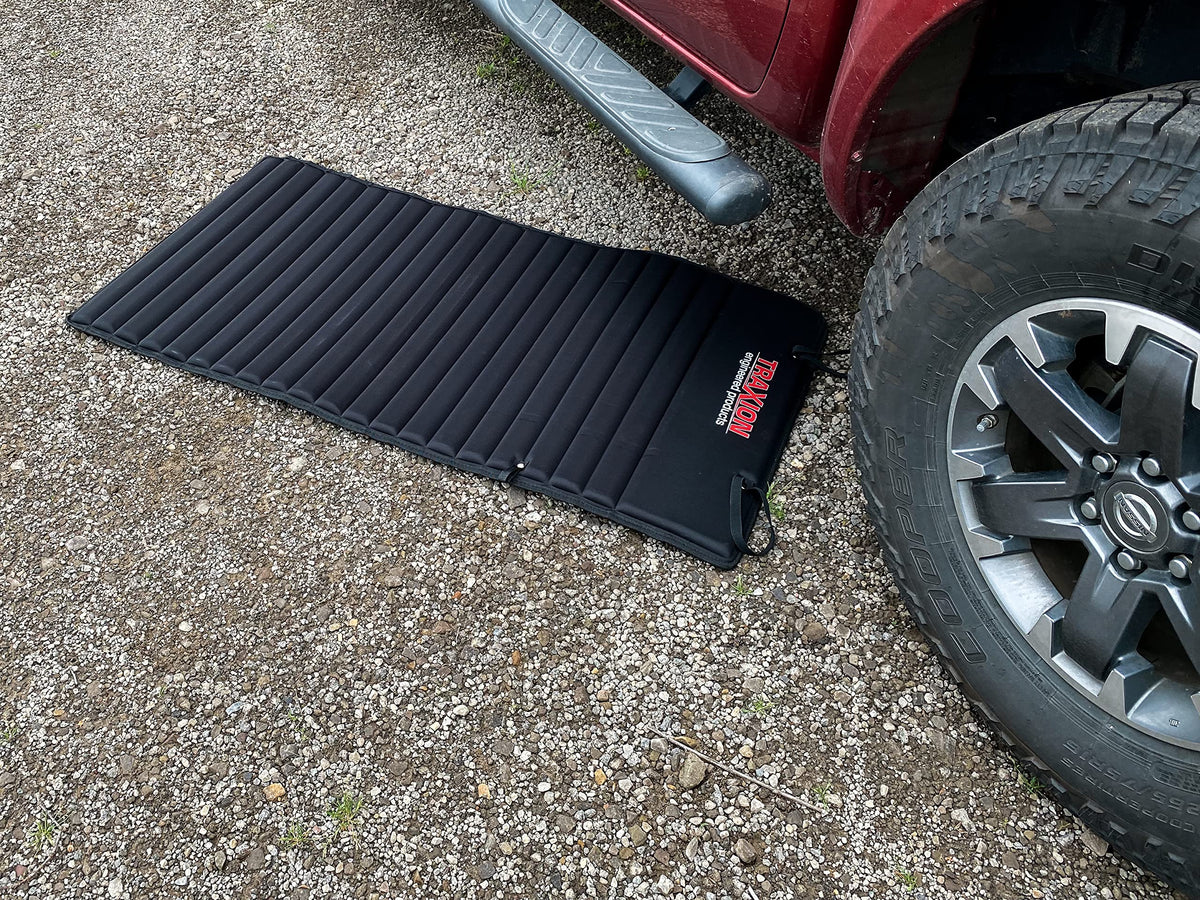 Traxion VersaMat in a garage under a car showing clean comfortable working surface