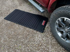 Traxion VersaMat in a garage under a car showing clean comfortable working surface