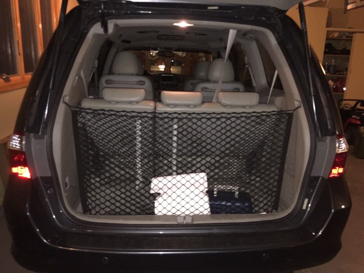 Trunknets Inc lifestyle scene of family loading trunk for road trip organization