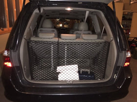 Trunknets Inc lifestyle scene of family loading trunk for road trip organization