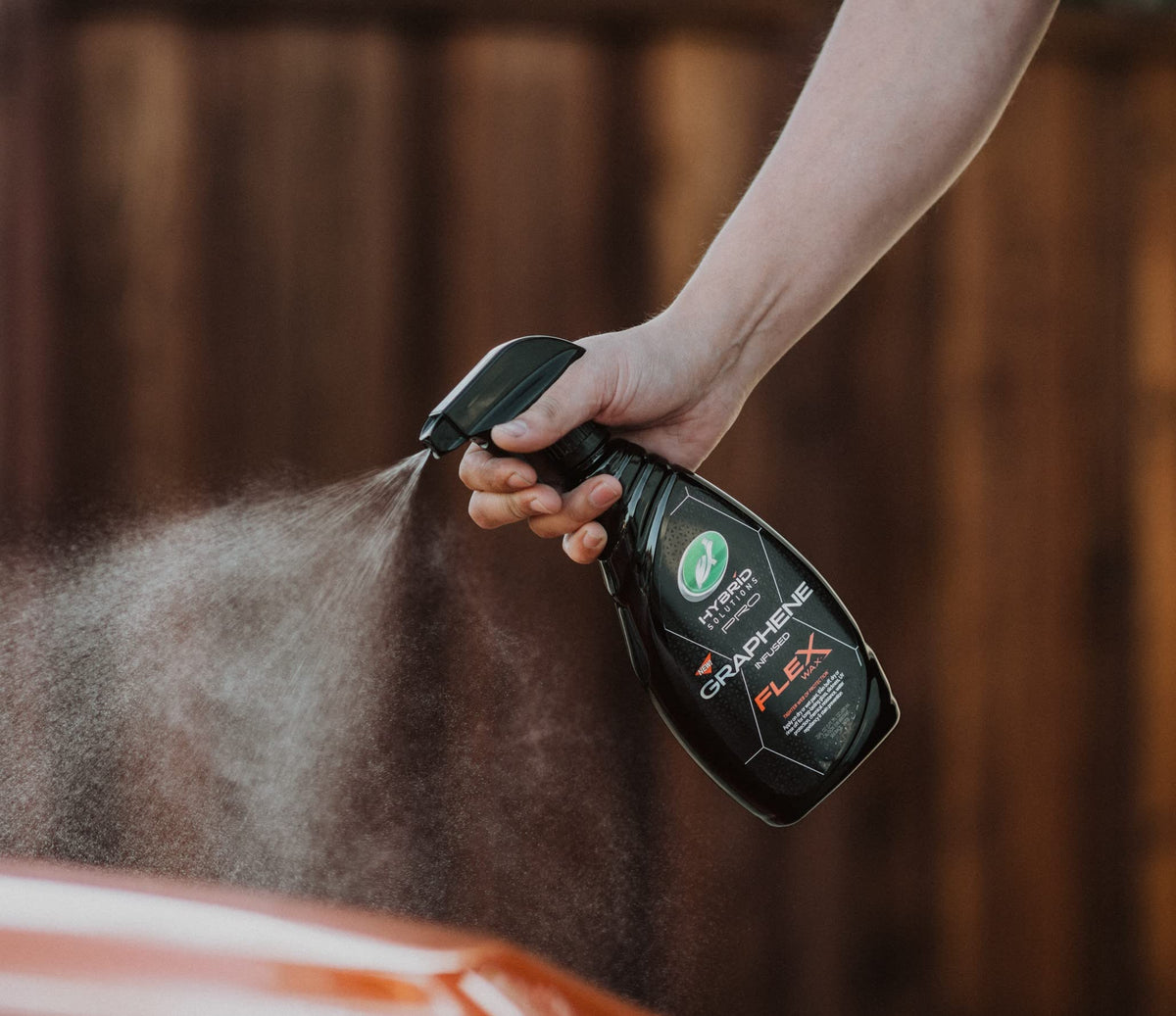 Turtle Wax being sprayed on car paint during detailing for quick shine and protection