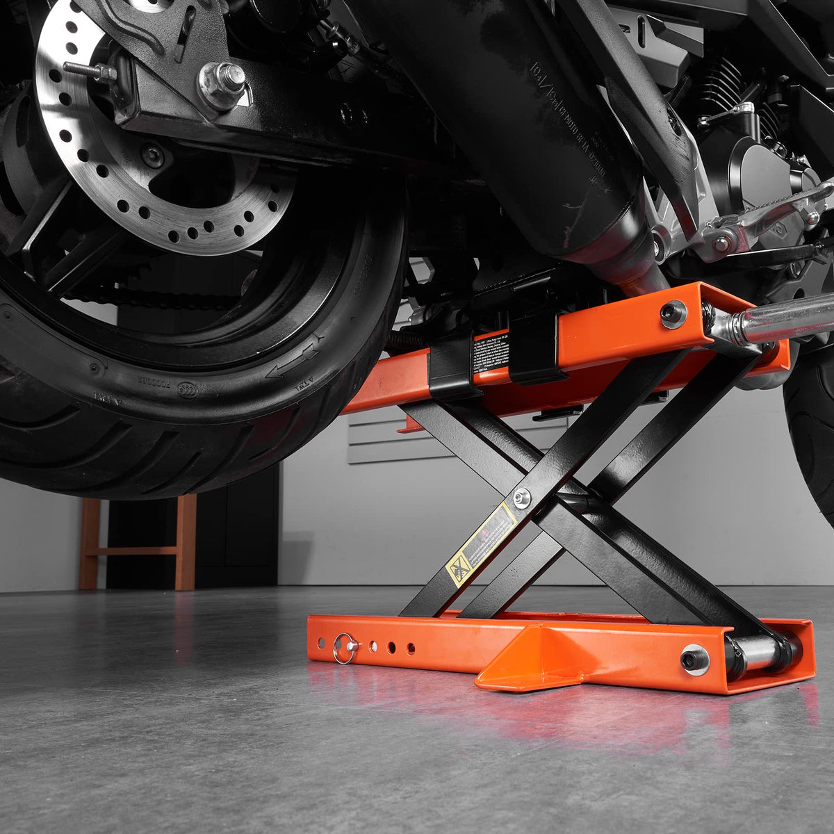 VEVOR lift under a motorcycle in a garage showing practical use