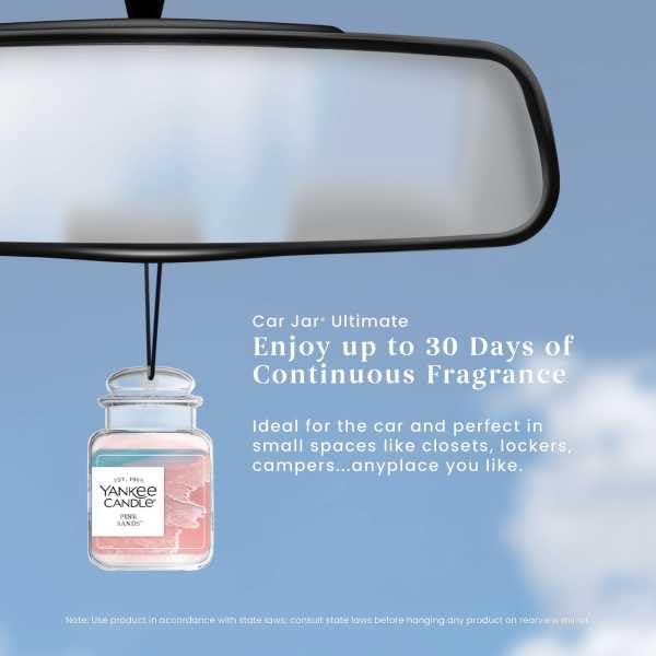 Yankee Candle Pink Sands next to phone showing compact size and portability
